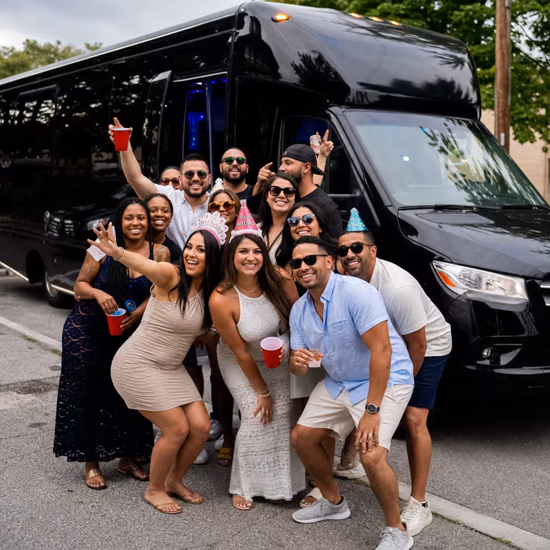 Group boarding a white charter bus for Birthday Transportation transportation in Newark