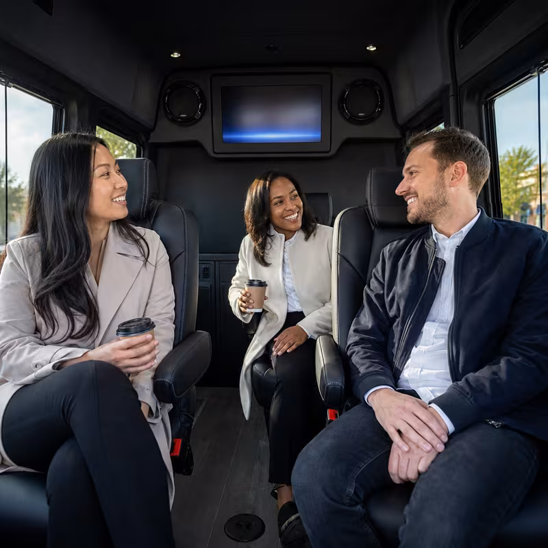 Group boarding a white charter bus for Corporate Transportation transportation in Newark