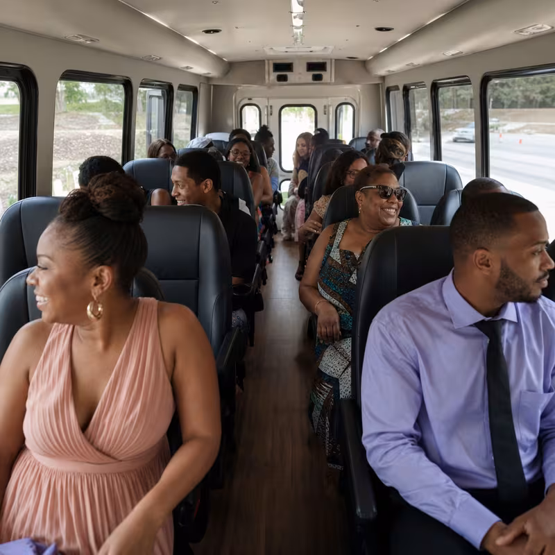 Group boarding a white charter bus for Private Event Transportation transportation in Newark