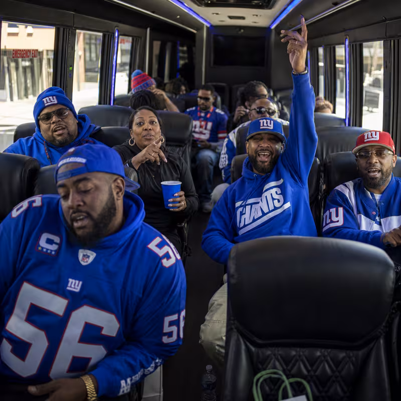 Group boarding a white charter bus for Sporting Event Transportation transportation in Newark